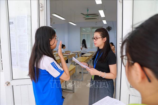 Giám thị kiểm tra thông tin thí sinh trước khi vào phòng thi tại Điểm thi trường THPT Đoàn Kết - Hai Bà Trưng (phường Bạch Mai). Ảnh: Khánh Hoà - TTXVN